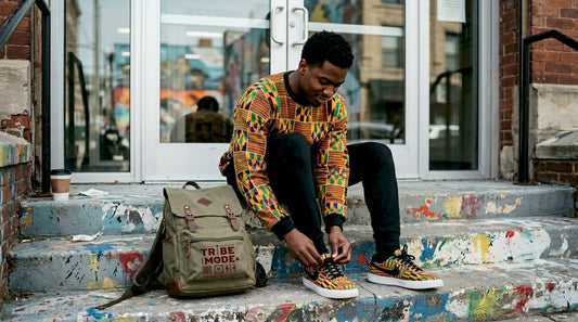 Young man tying shoes in African print sweatshirt